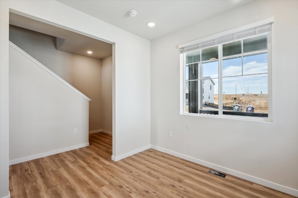 A room with a window and a wood floor.