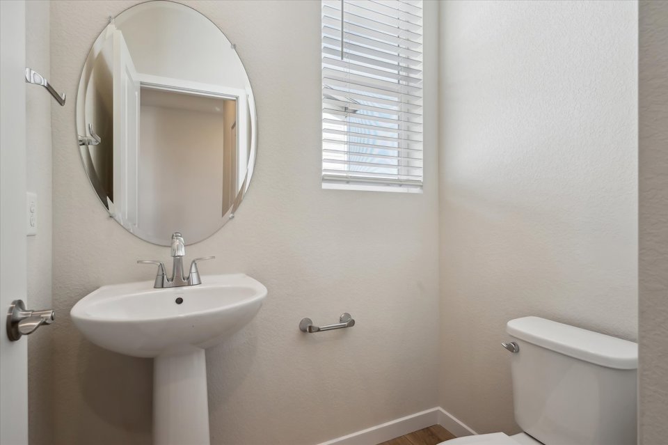 A bathroom with a round mirror.