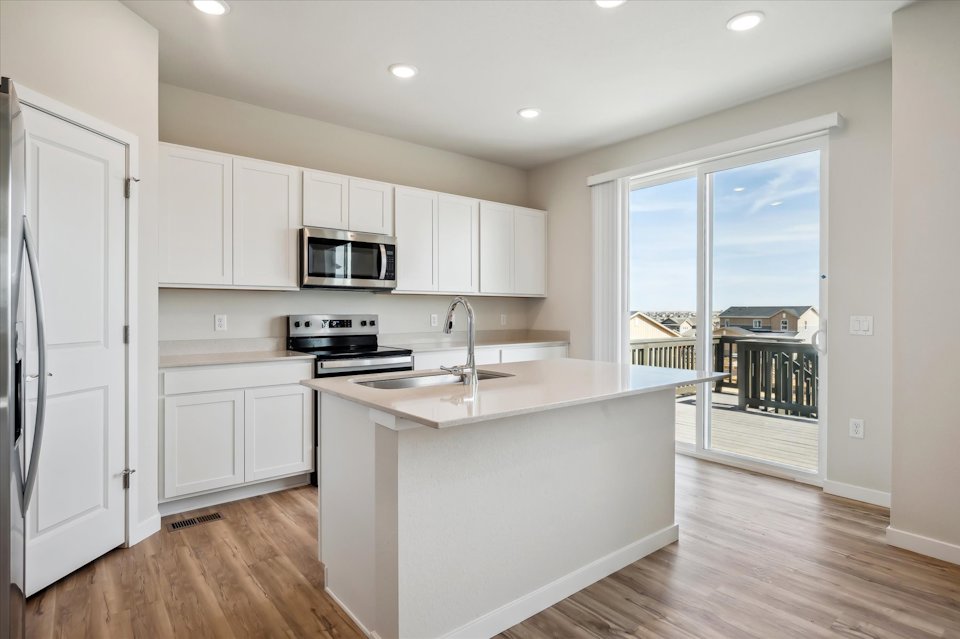 A kitchen with white cabinets.