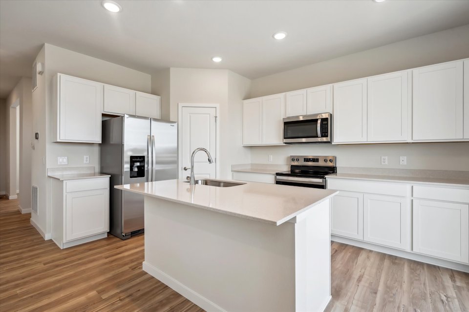 A kitchen with white cabinets.