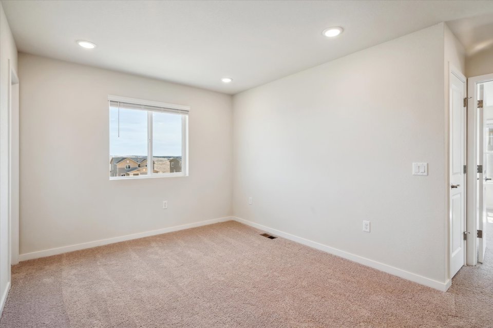 A room with a window and a carpet.