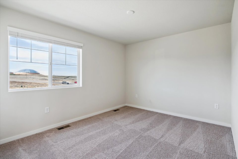 A room with a window and a carpet.