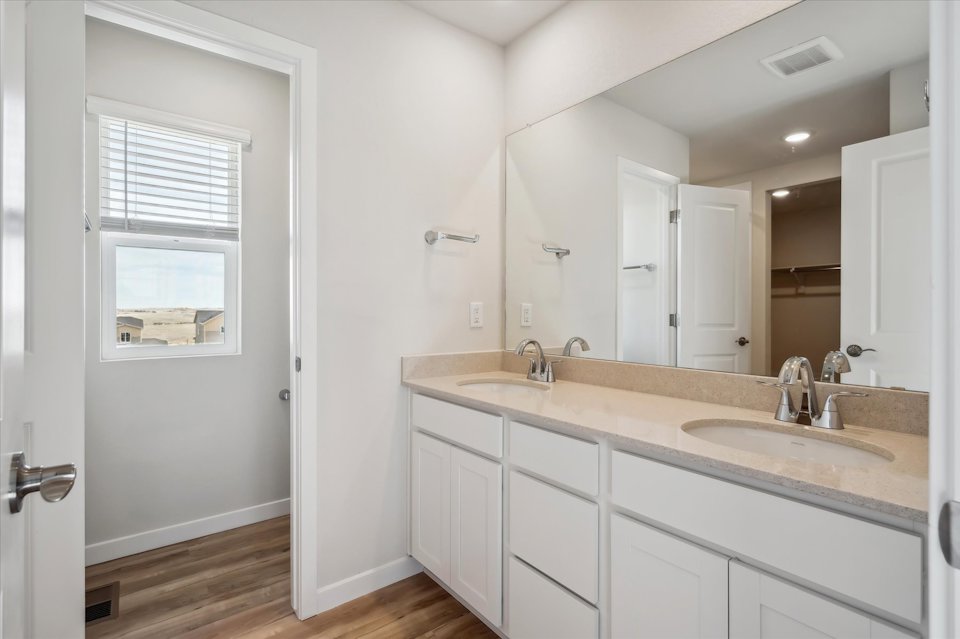 A bathroom with white cabinets.