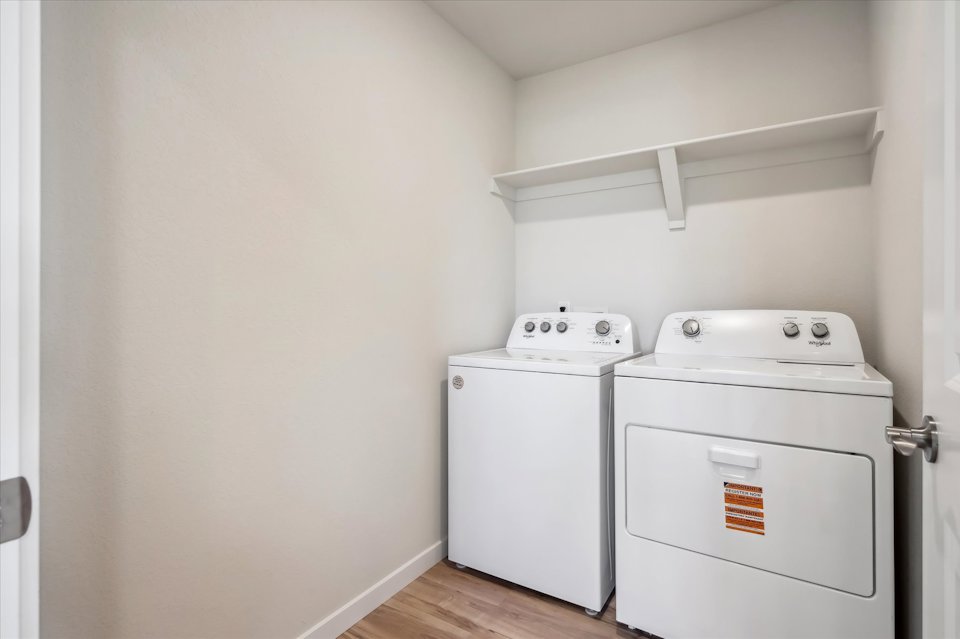 A white laundry room with a washer and dryer.