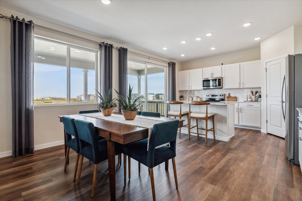 A kitchen with a dining table and chairs.