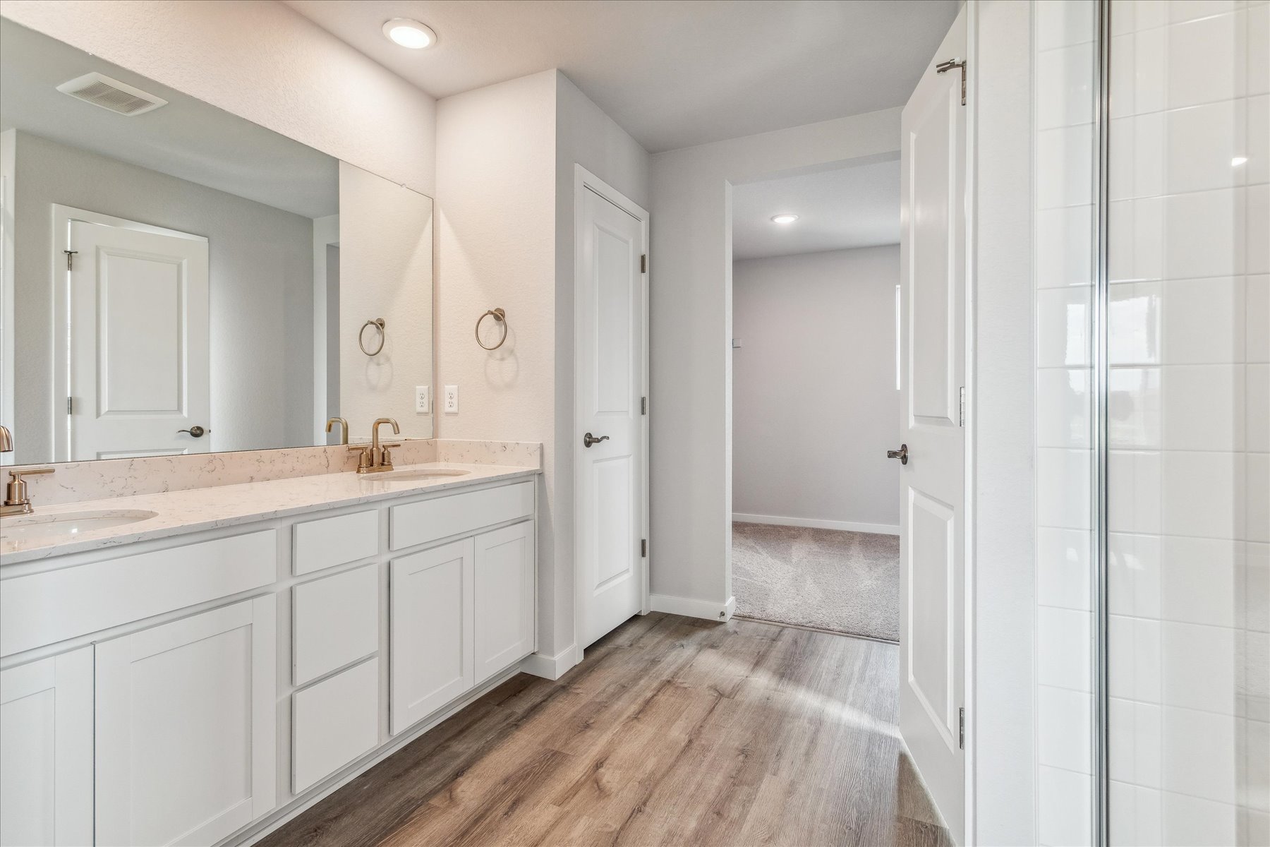 A bathroom with white cabinets.