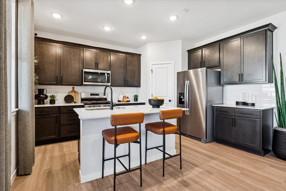 A kitchen with black cabinets.