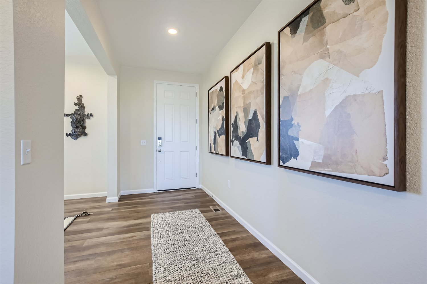 A hallway with a rug and a door.