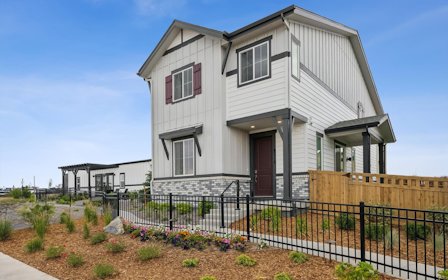 A white house with a black fence.