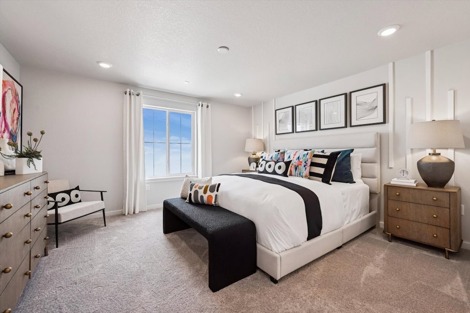 A bedroom with a bed and dresser.