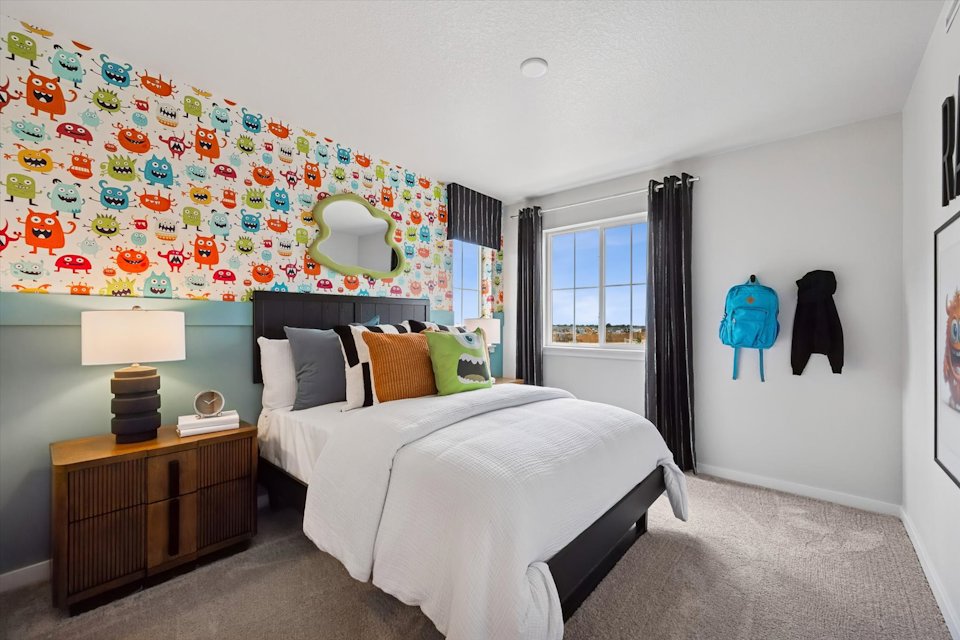 A bedroom with a bed and a lamp.