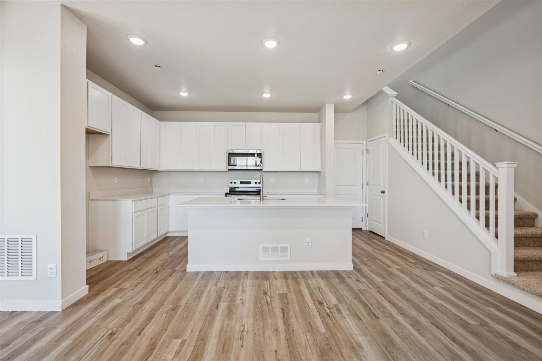 A kitchen with white cabinets.
