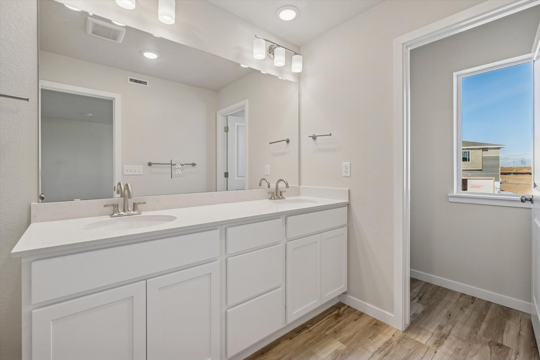 A bathroom with white cabinets.