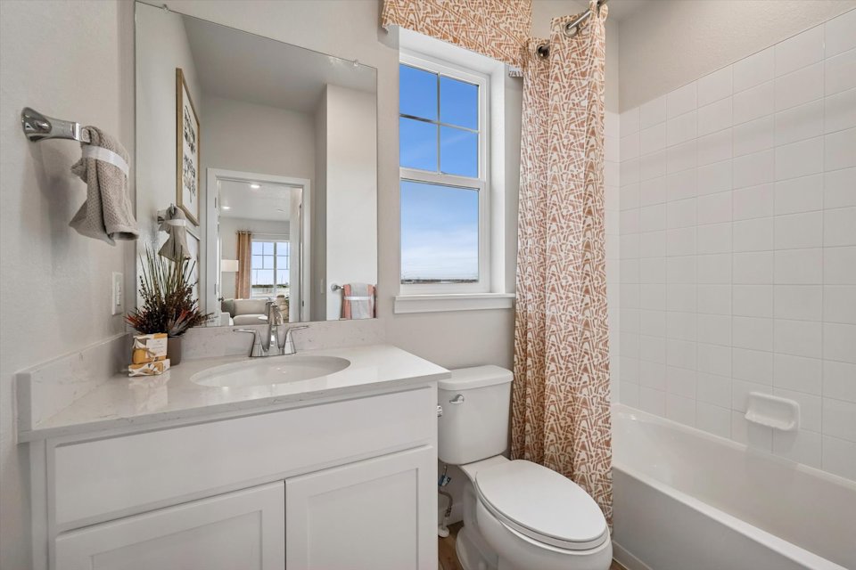 A bathroom with a tub sink and toilet.