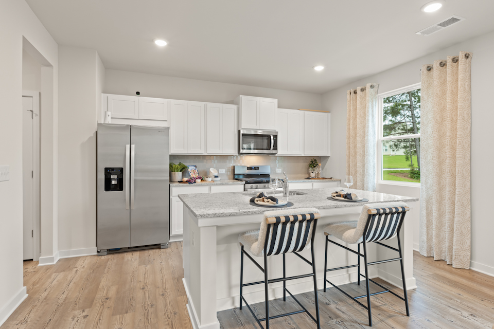 A kitchen with white cabinets.