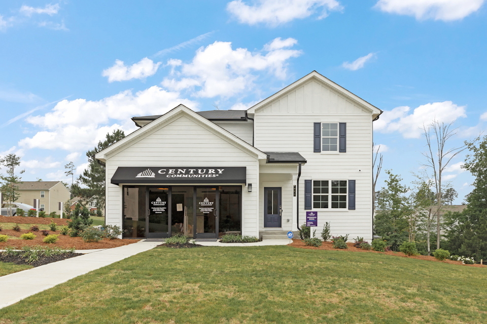 A white building with a sign on it with Southfork Ranch in the background.