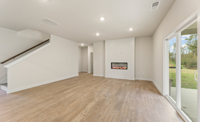 A room with a fireplace and a wood floor.