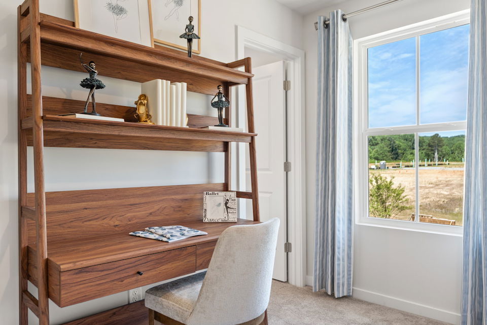 A chair and a desk in a room with windows.