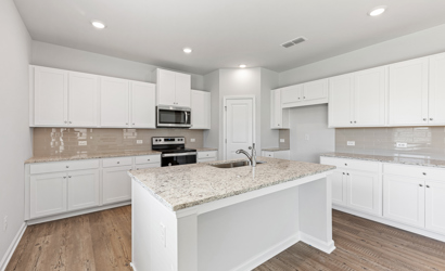 A kitchen with white cabinets.