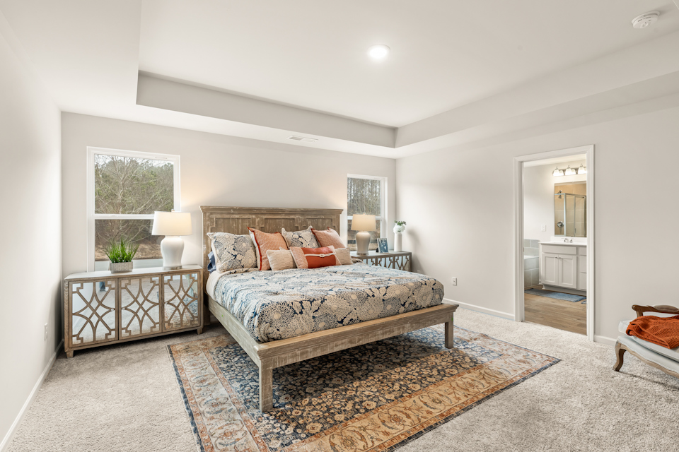 A bedroom with a bed and a table.