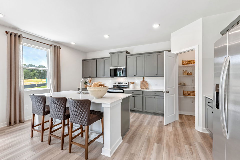 A kitchen with a dining table and a large window.