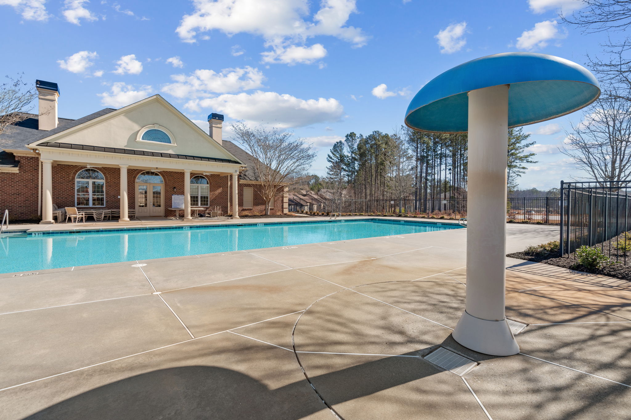A swimming pool in front of a house.