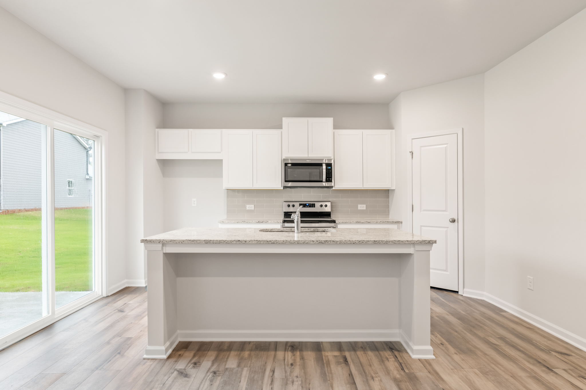 A kitchen with white cabinets.