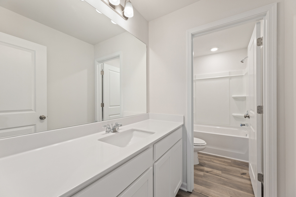 A bathroom with a tub sink and toilet.