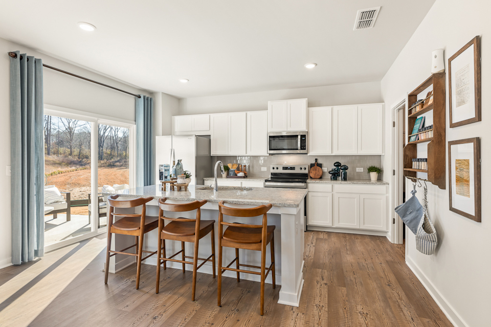 A kitchen with a dining table and chairs.