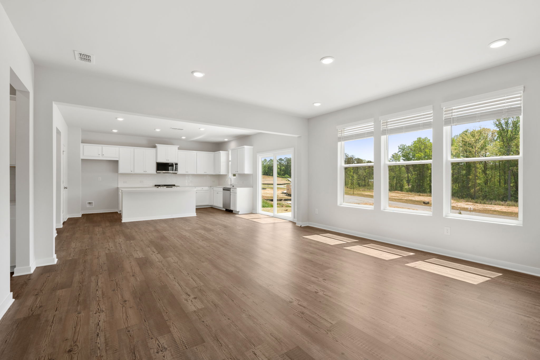 A large empty room with white cabinets.