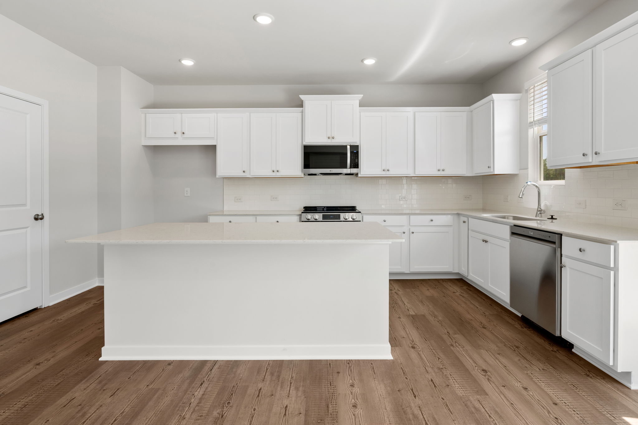 A kitchen with white cabinets.