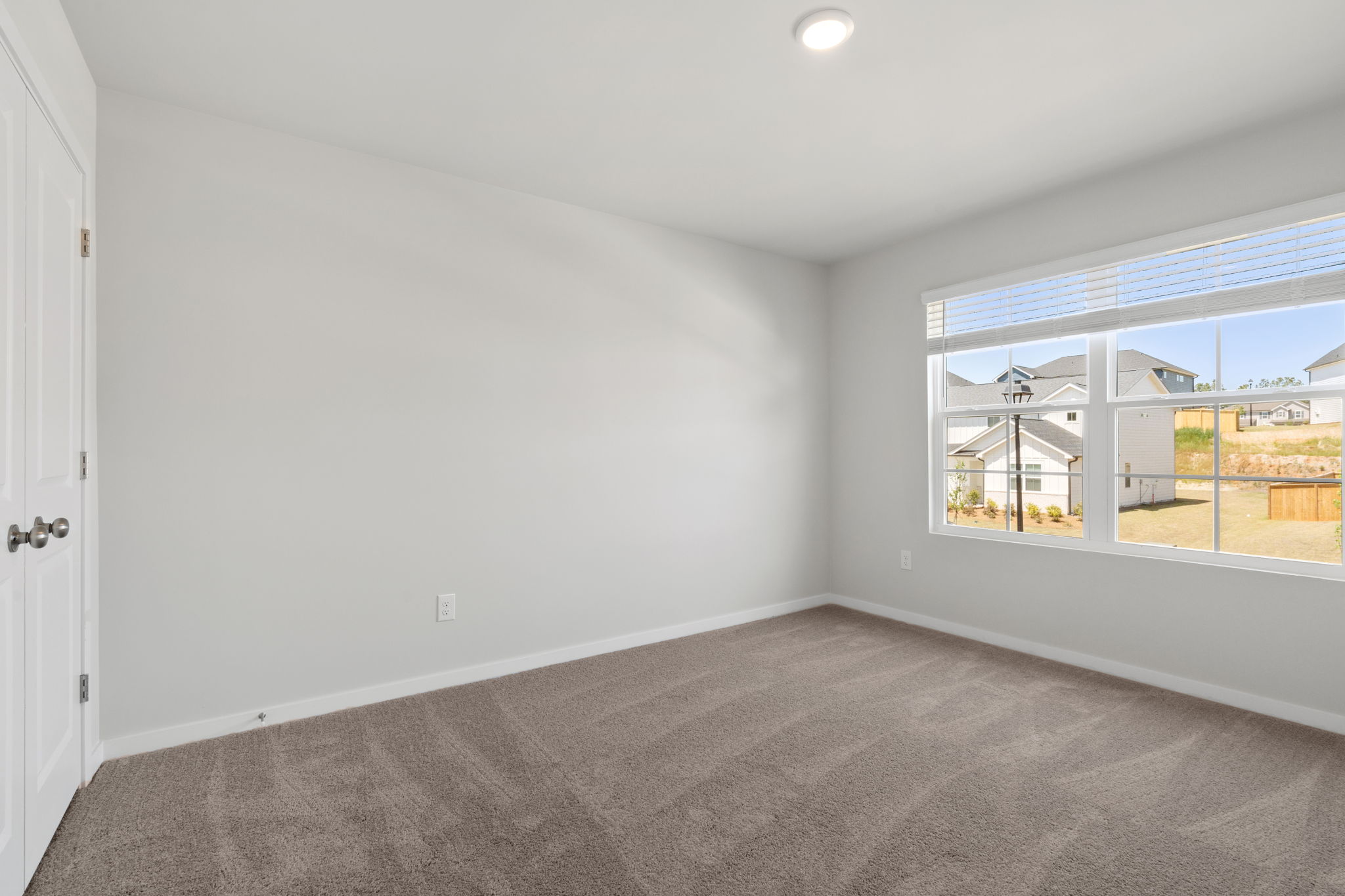 A room with a window and a carpet.