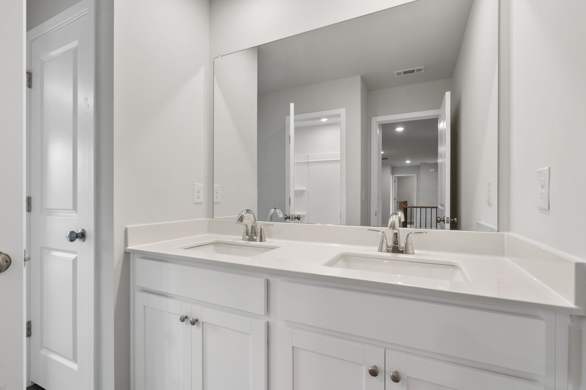 A bathroom with a large mirror.