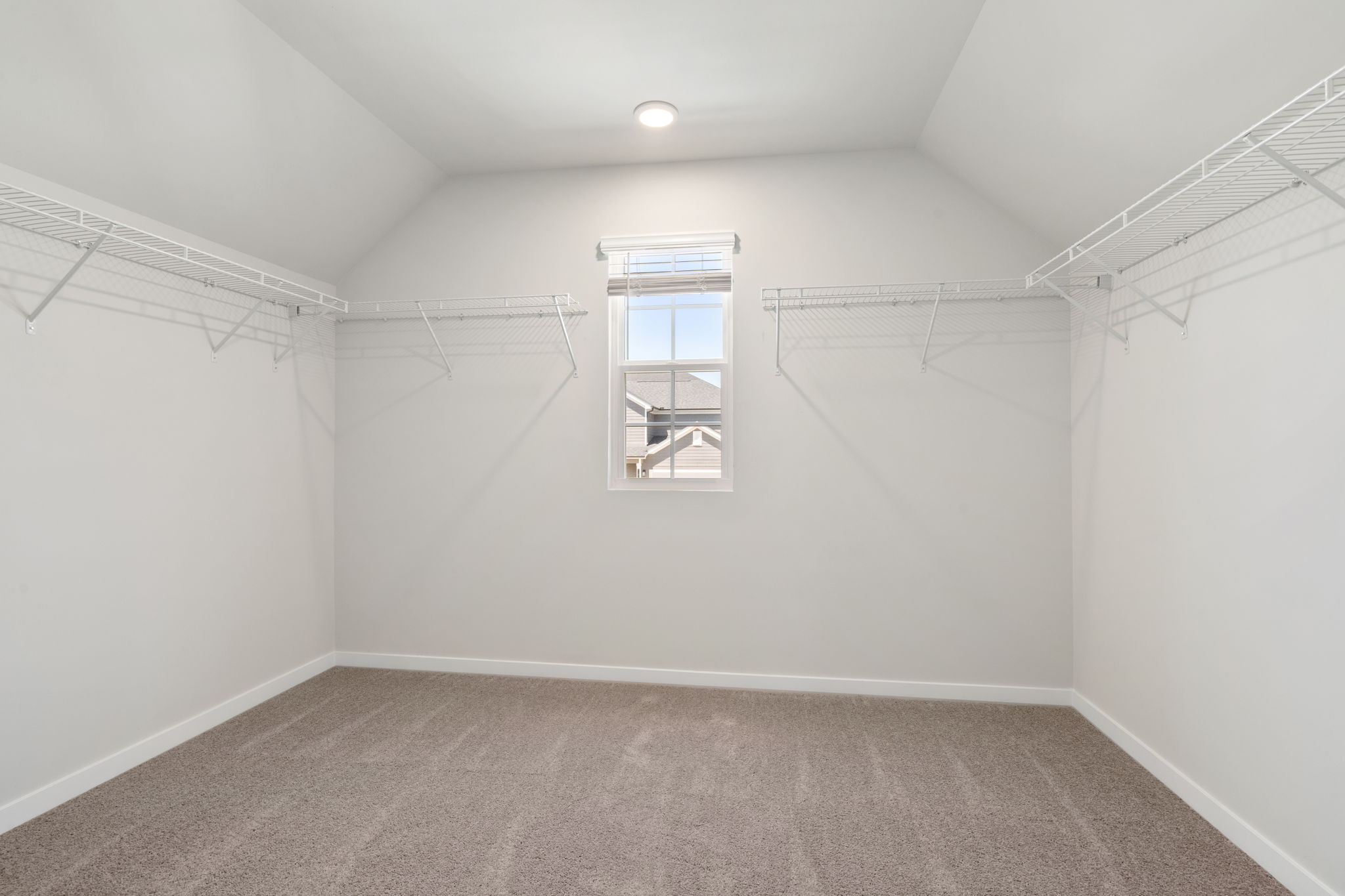 A room with a window and a carpet.