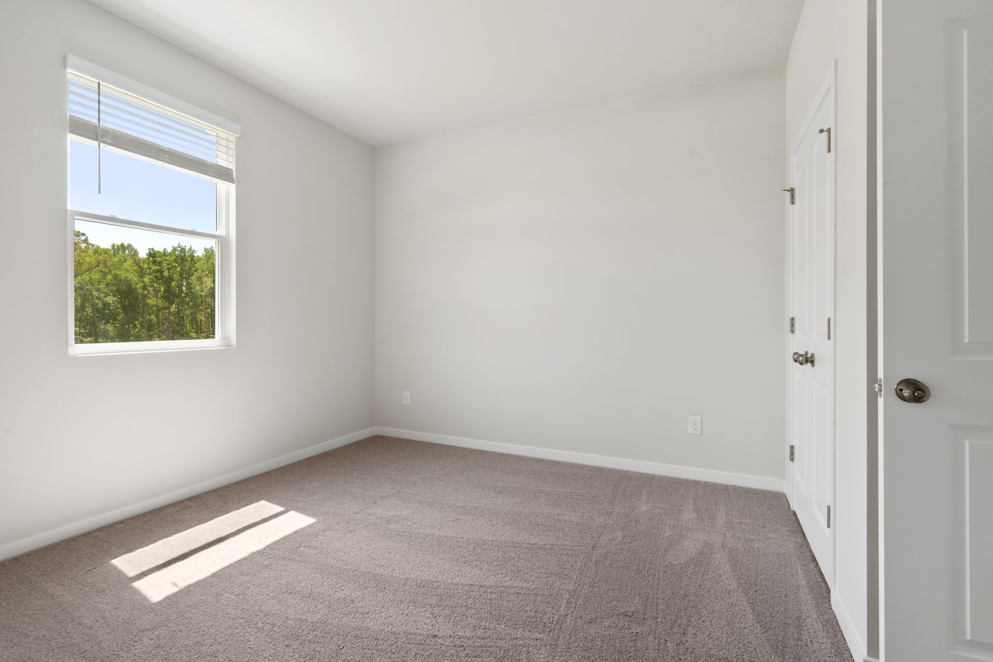 A room with white walls and a window.