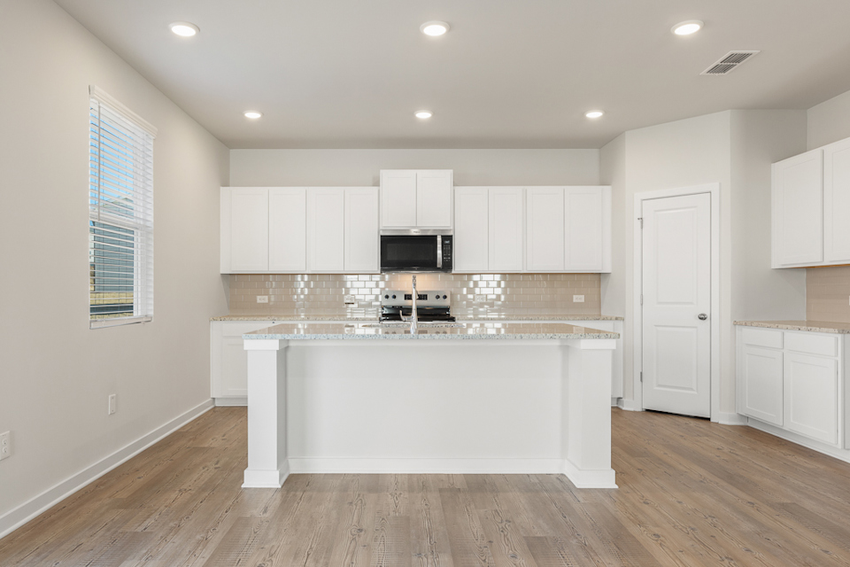 A kitchen with white cabinets.