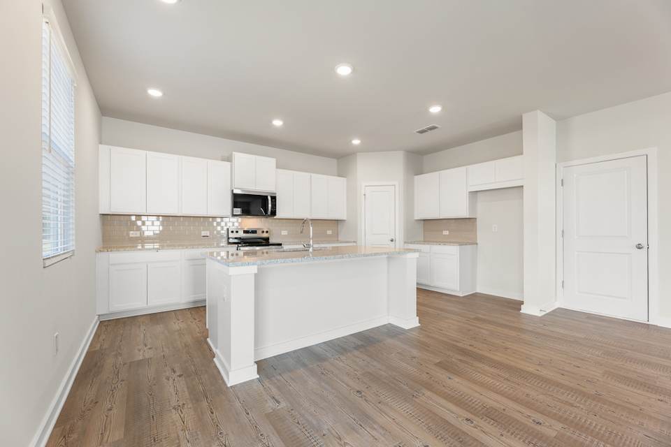 A kitchen with white cabinets.