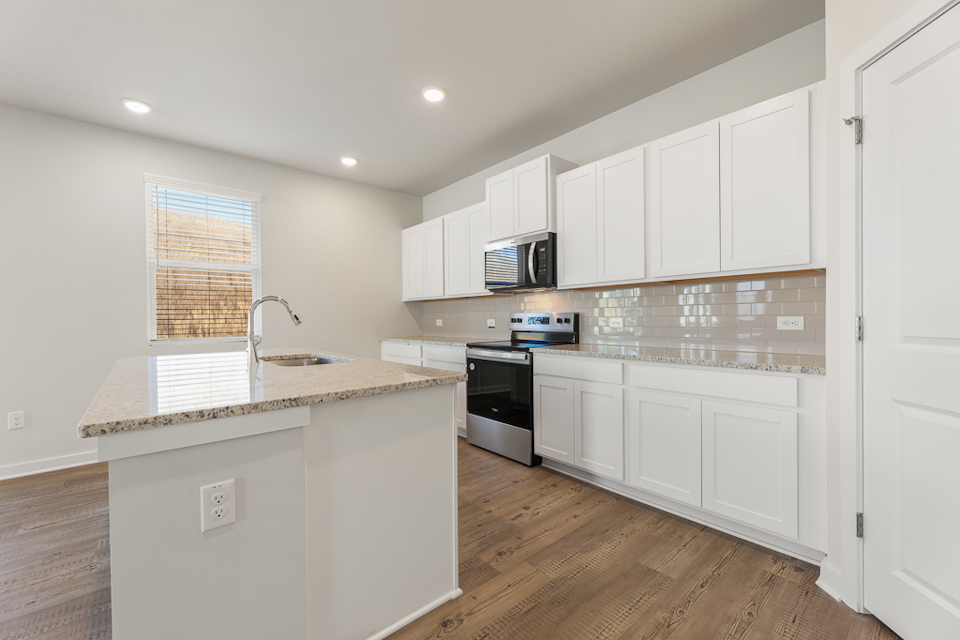 A kitchen with white cabinets.