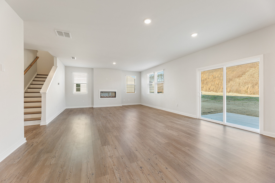 A large empty room with a wood floor and a wood floor.