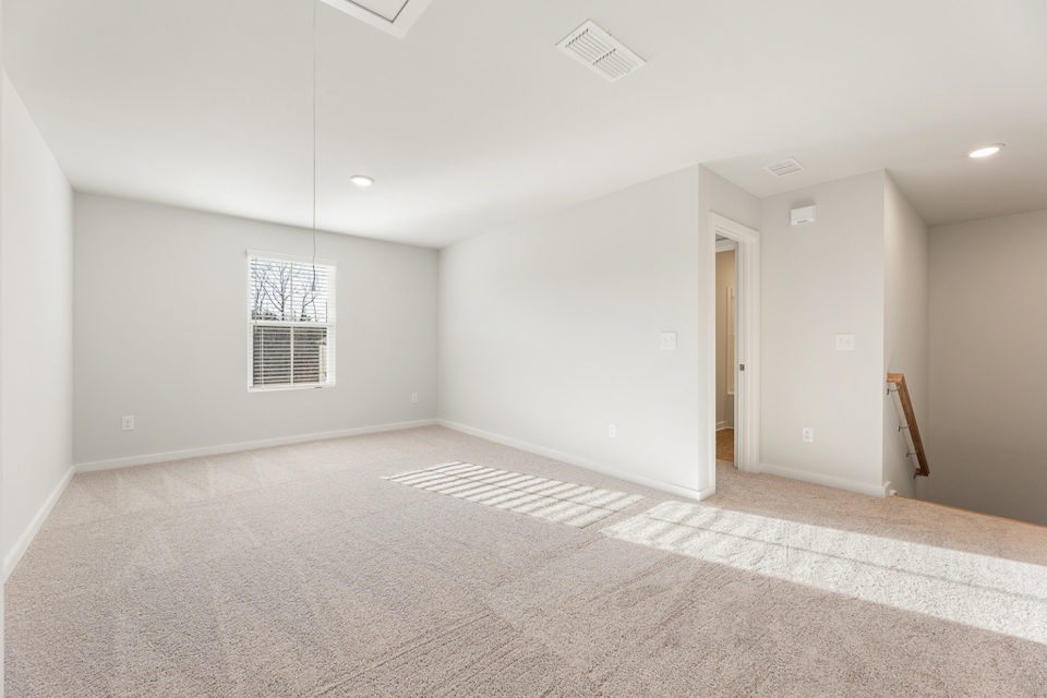 A room with a carpet and a door.