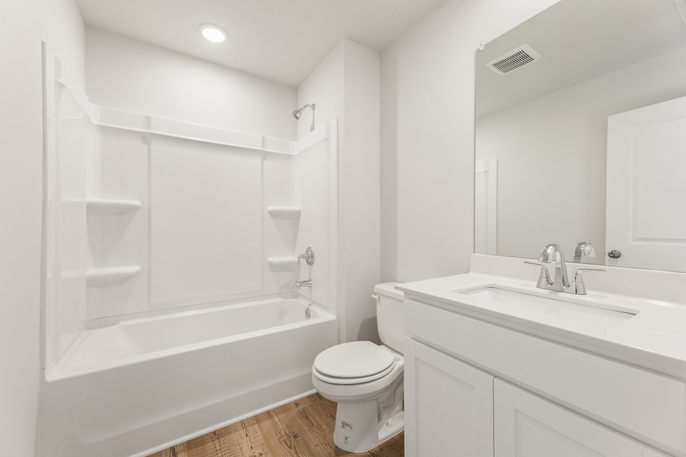 A bathroom with a tub sink and toilet.