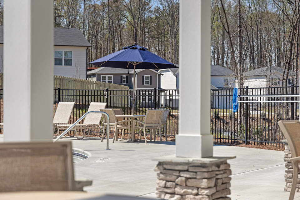 A patio with tables and chairs.