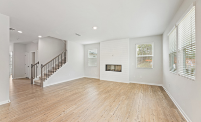 A large empty room with a wood floor and white walls.