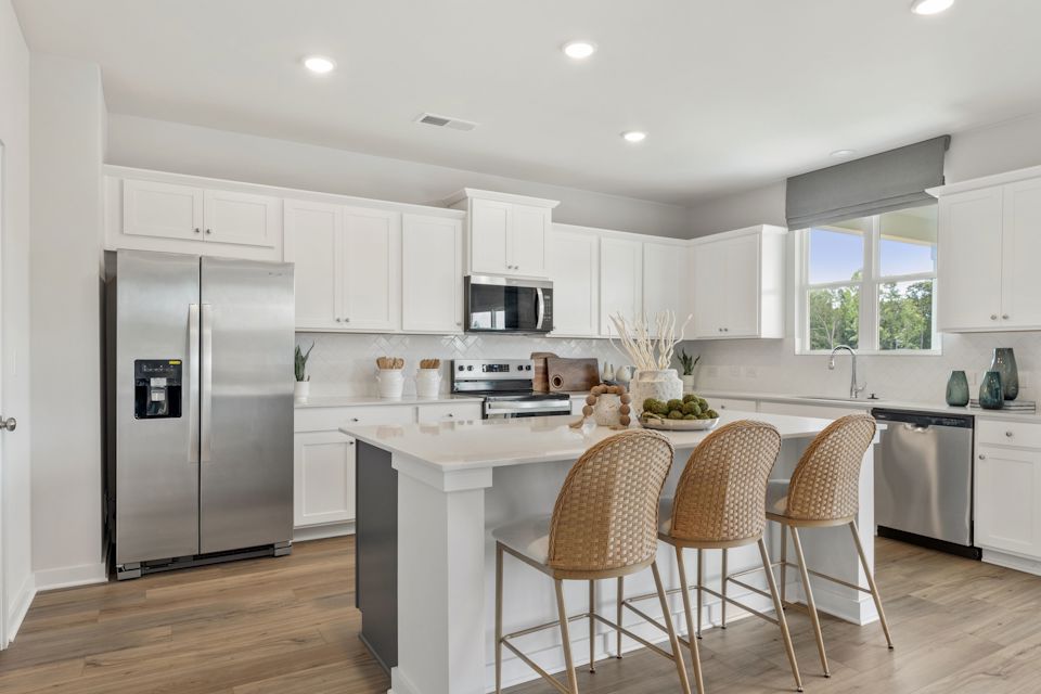 A kitchen with white cabinets.