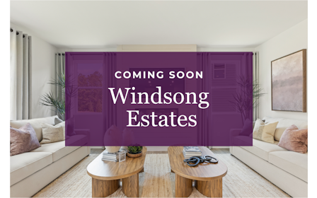 A room with a couch and a table with a sign on it.