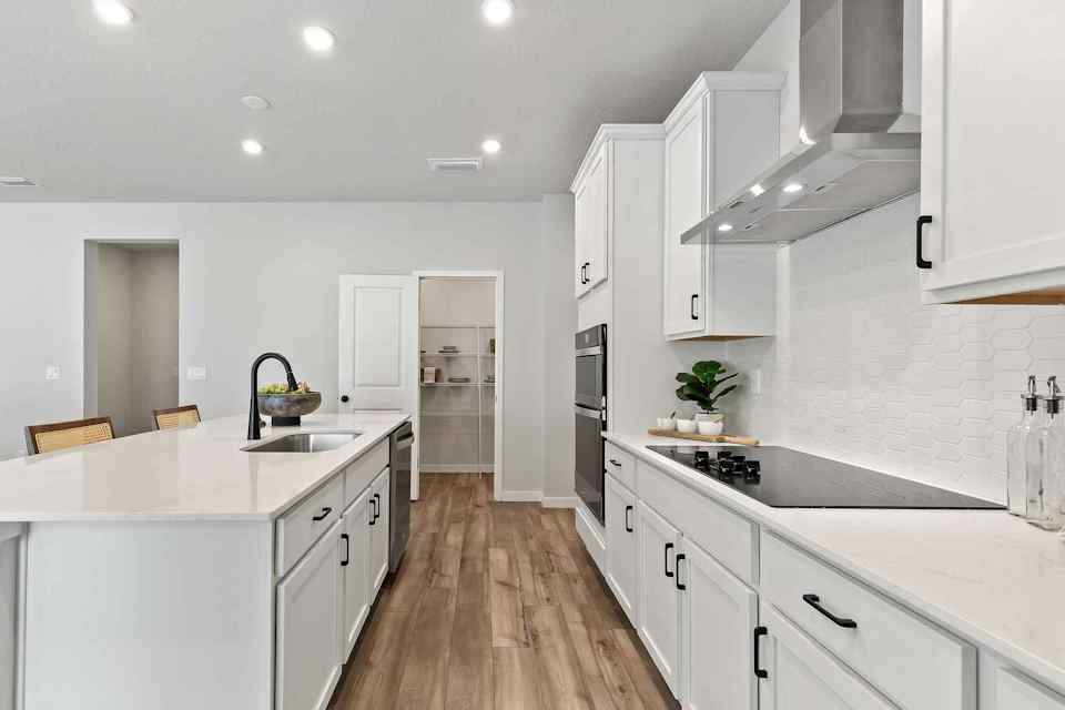 A kitchen with white cabinets.