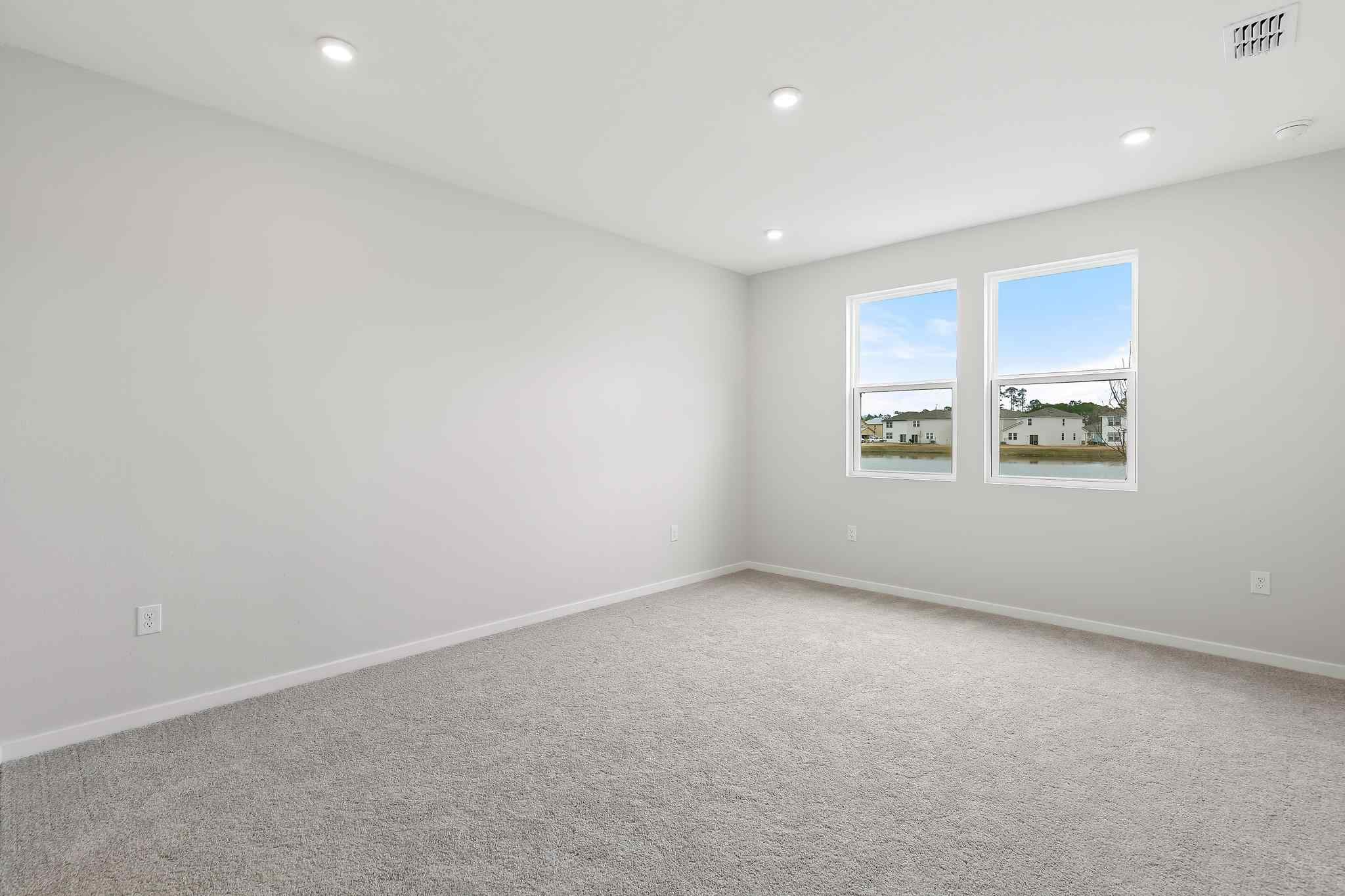 A room with a window and a wall with a painting on it.