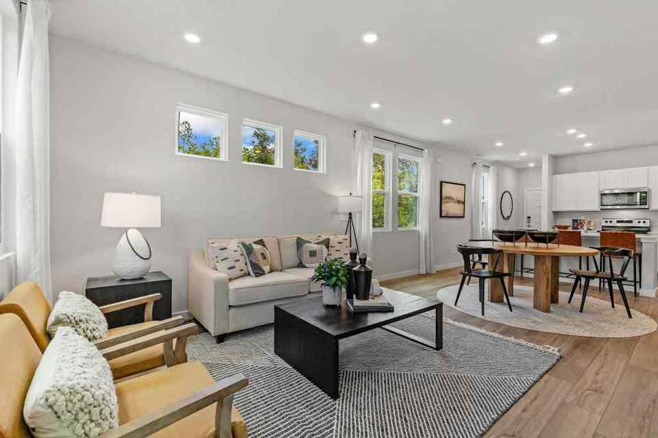 A living room with a large rug and a table.
