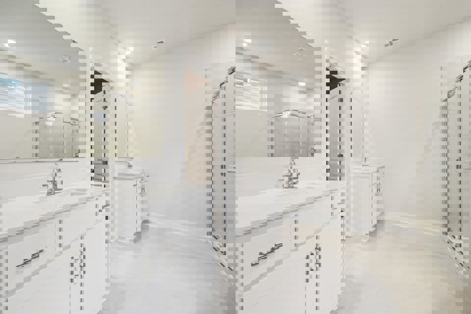 A bathroom with white cabinets.