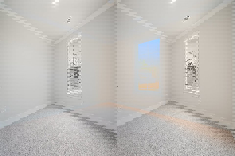 A room with a window and carpet.